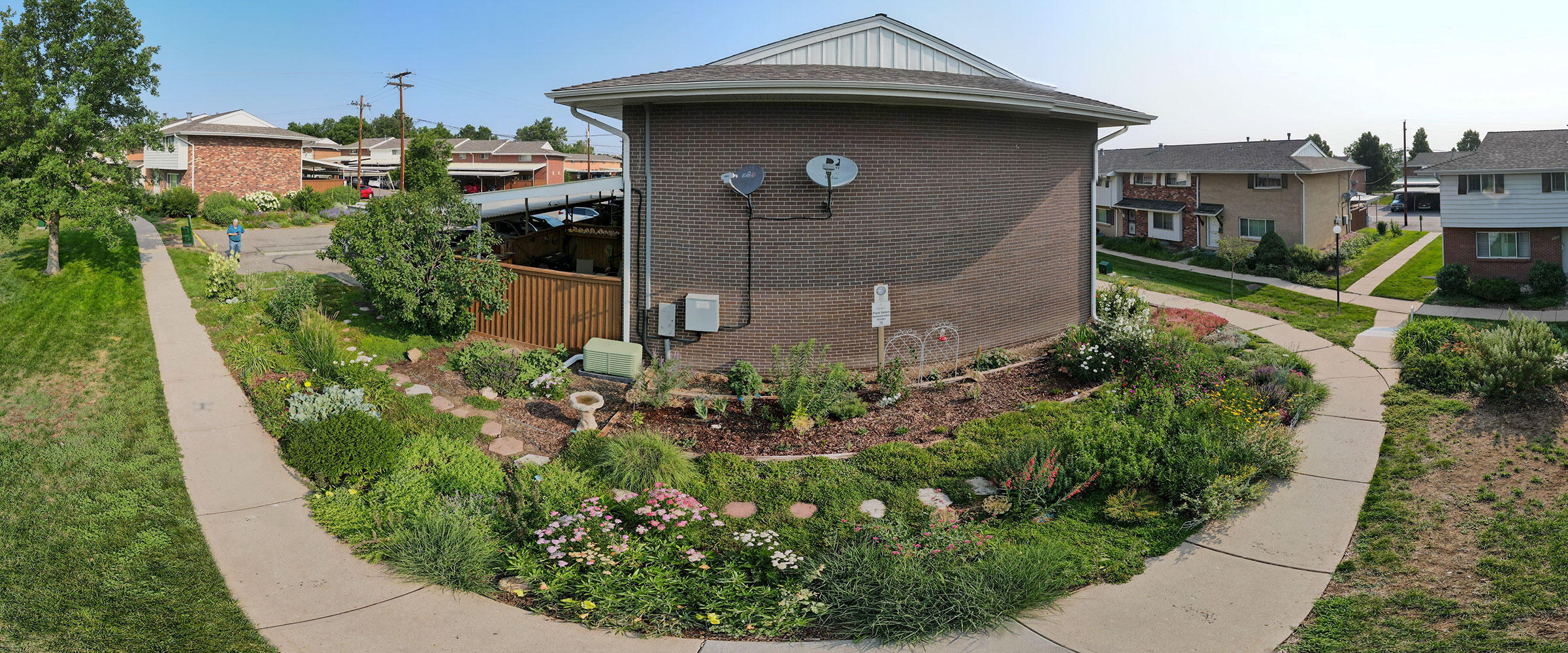 Panorama of a garden of flowers in front of a condo.